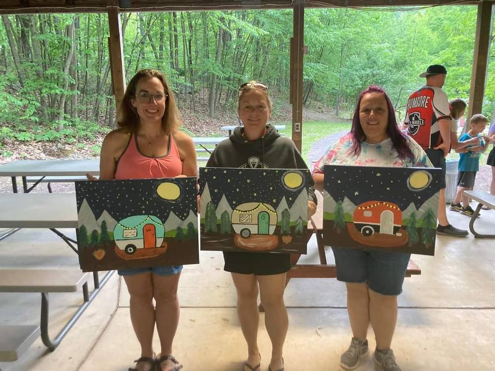 Campers showing paintings at a craft event